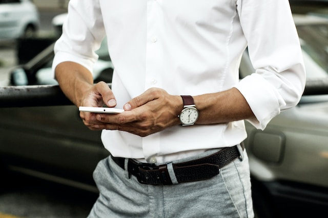 Man in a white shirt playing online casino on his phone